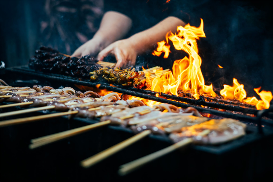 Food Photography in SG : Street vendor preparing traditional satay skewers over charcoal fire