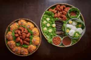 Two ornate communal platters showcasing Chinese-Malay fusion cuisine: the left tray features crispy fried chicken nestled in shredded vegetables and lettuce cups, evoking hawker-style abundance; the right tray presents a curated mix of grilled meats, flower-garnished rice mounds, and fiery condiments, symbolizing the bold, forbidden union of Peranakan and Nyonya traditions in Singapore’s evolving culinary identity.