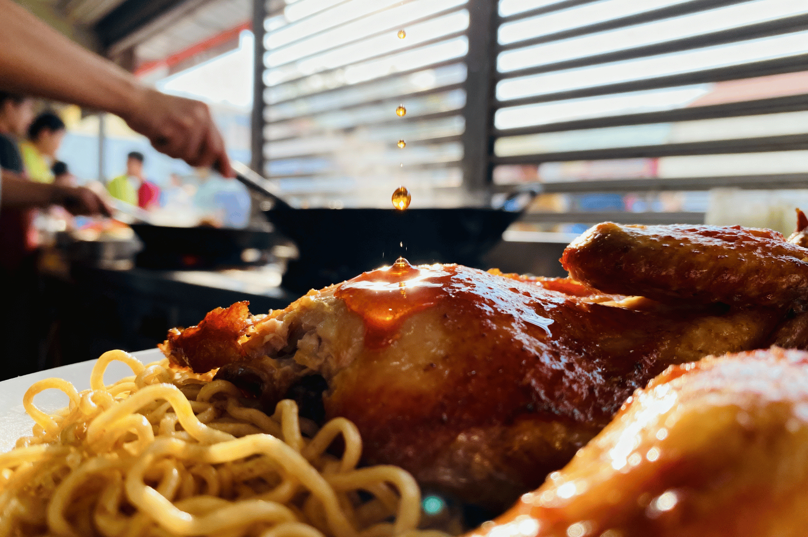 Macro-Photography- (2) Close-up of glossy soy-glazed chicken with sesame seeds over springy egg noodles, shot in Singapore, highlighting rich textures and steam on a white plate.