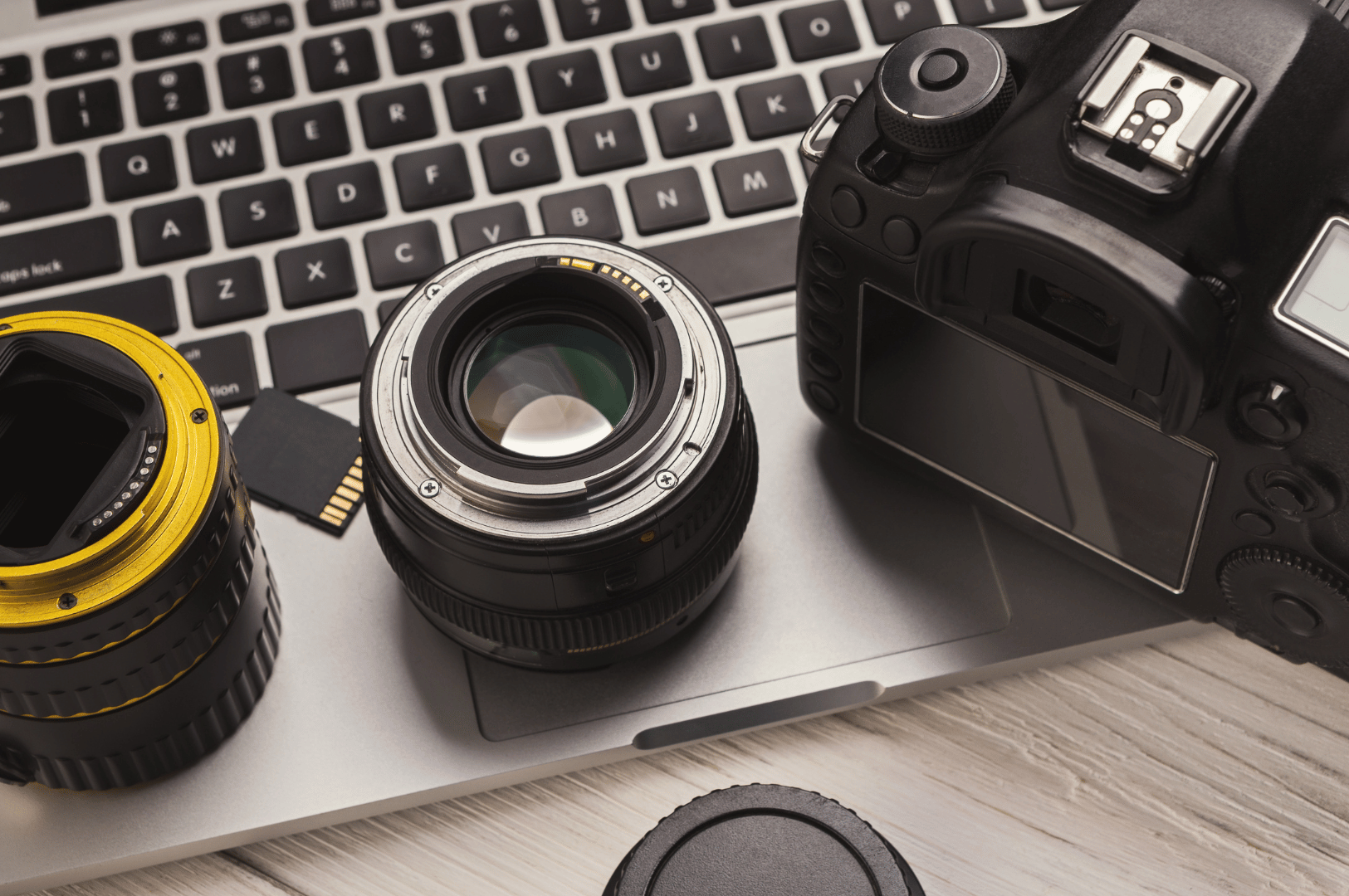 Night-market-Pics- (2) A top-down view of a DSLR camera, lenses, and memory card arranged on a laptop keyboard—an intimate glimpse into a food photographer’s digital toolkit, where tactile gear meets the glow of post-processing workflows