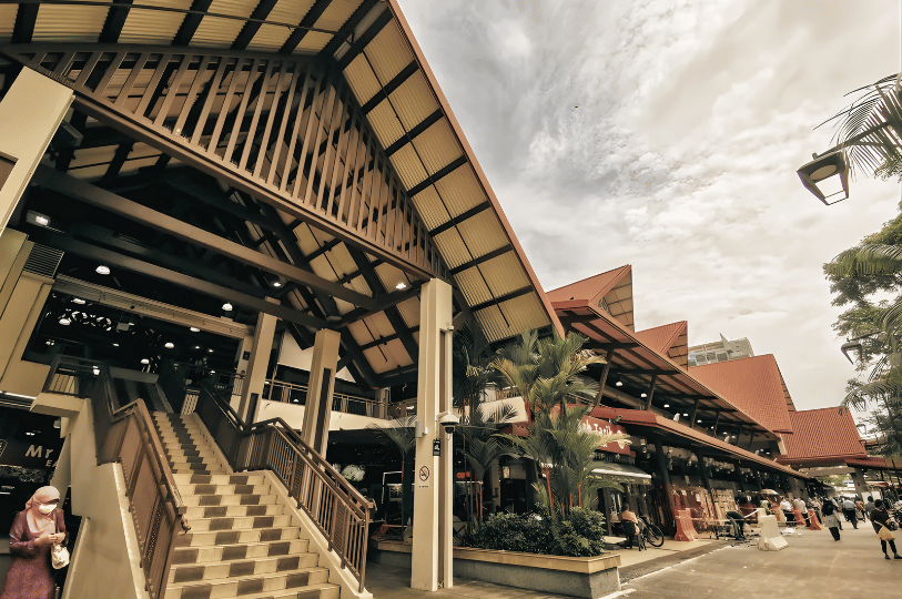 A plate of Nasi Ayam Penyet featuring a mound of white rice, crispy fried chicken wings, fried tofu (tahu), tempeh, and a side of spicy sambal and dark soy sauce.