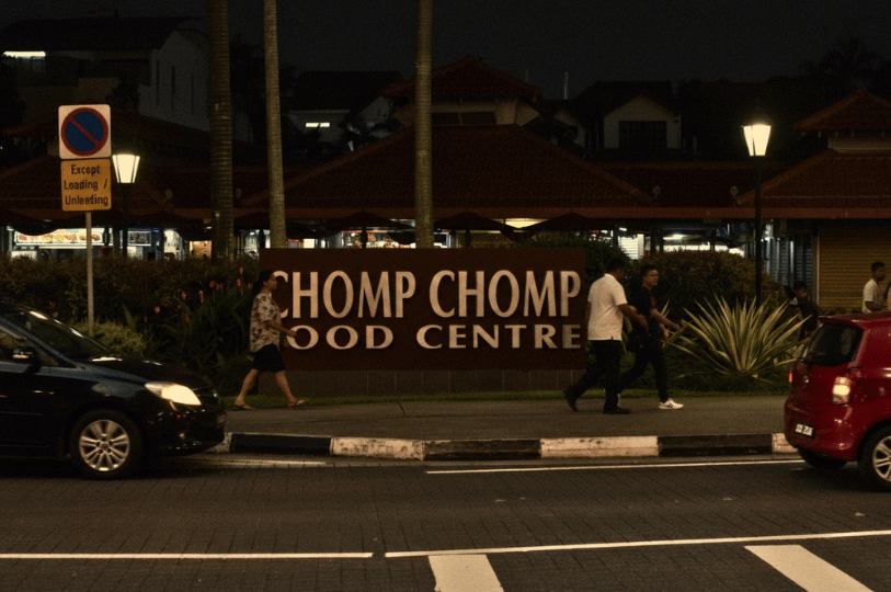 The roadside entrance sign of Chomp Chomp Food Centre in Serangoon Gardens, a popular late-night destination famous for satay and sambal stingray.