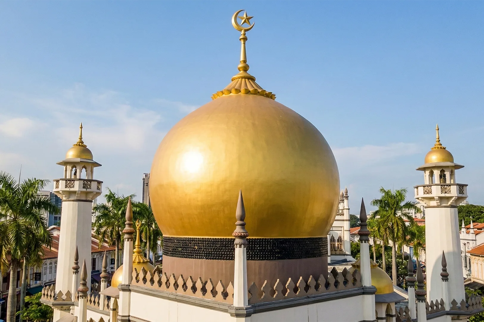 2-sultan-mosque-golden-dome-singapore.webp Close-up of the iconic golden dome and minarets of the Sultan Mosque (Masjid Sultan) against a clear blue sky in Singapore.