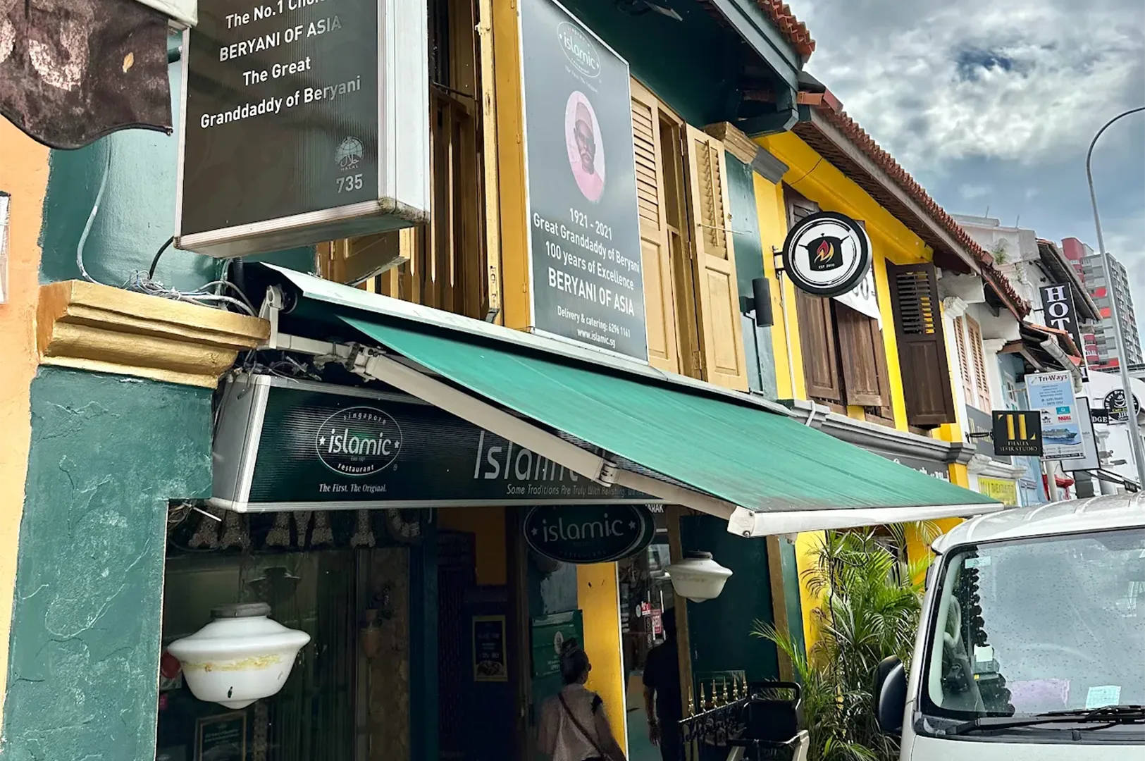 3-islamic-restaurant-north-bridge-road.webp The exterior of the historic Islamic Restaurant on North Bridge Road, known for its beryani, showing traditional green and yellow architecture.