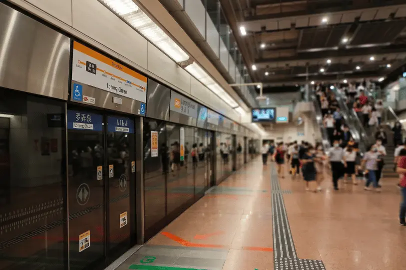 Commuters walk along the platform and ride the escalators inside the brightly lit Lorong Chuan MRT station on the Circle Line.